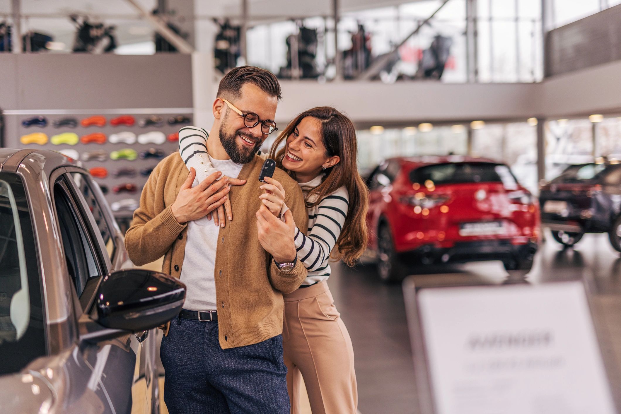 Couple receiving car keys, representing auto insurance decisions
