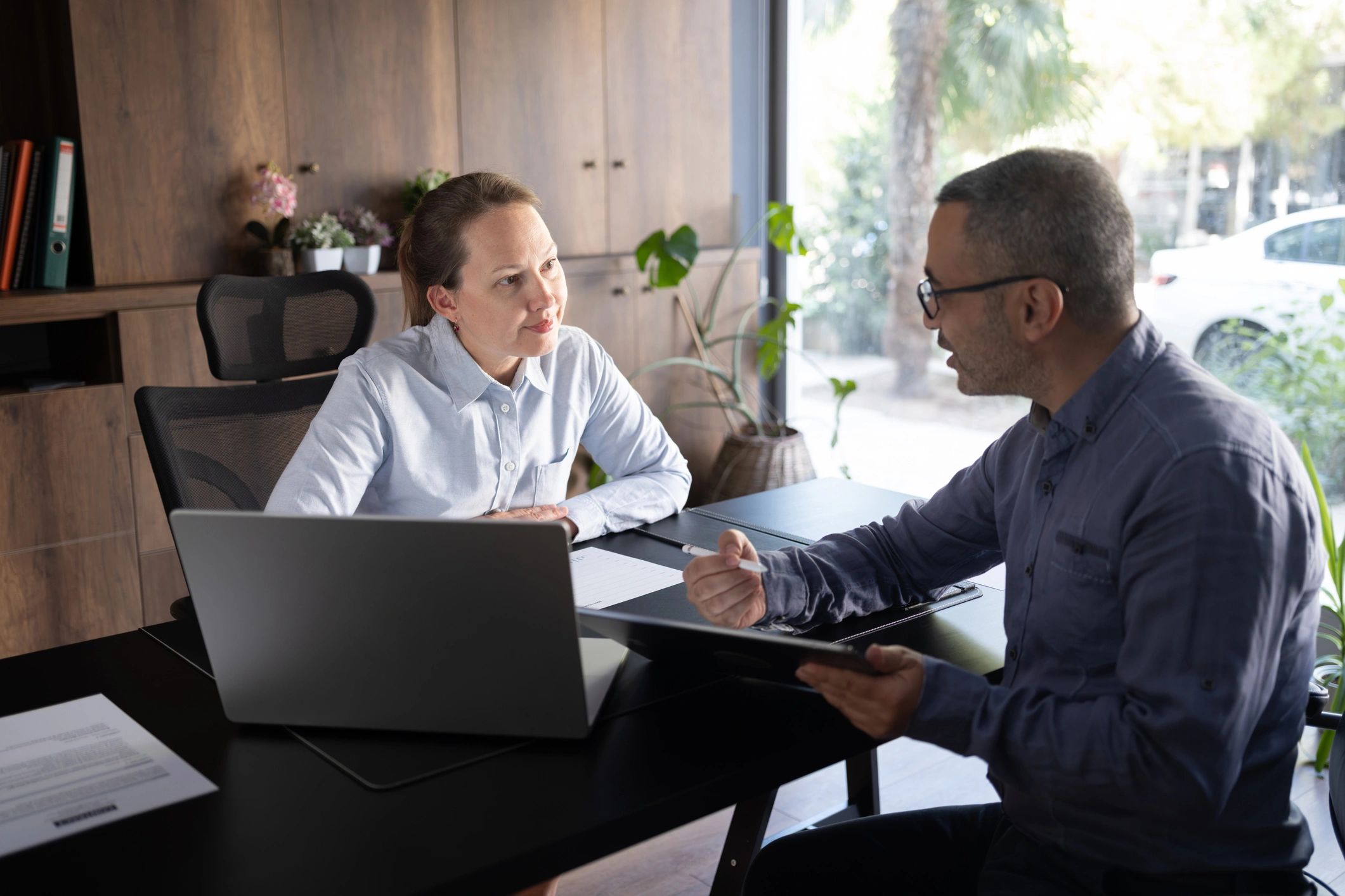 Two professionals discussing documents in an office